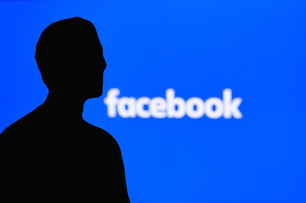 Mark Zuckerberg silhouette in front of Facebook logo