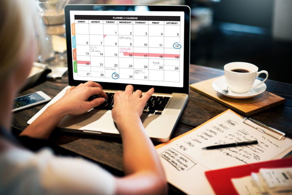 female looking at social media marketing events calendar on laptop