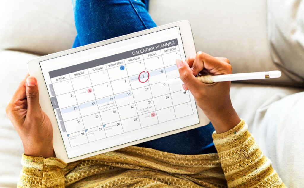 woman editing calendar on smart tablet