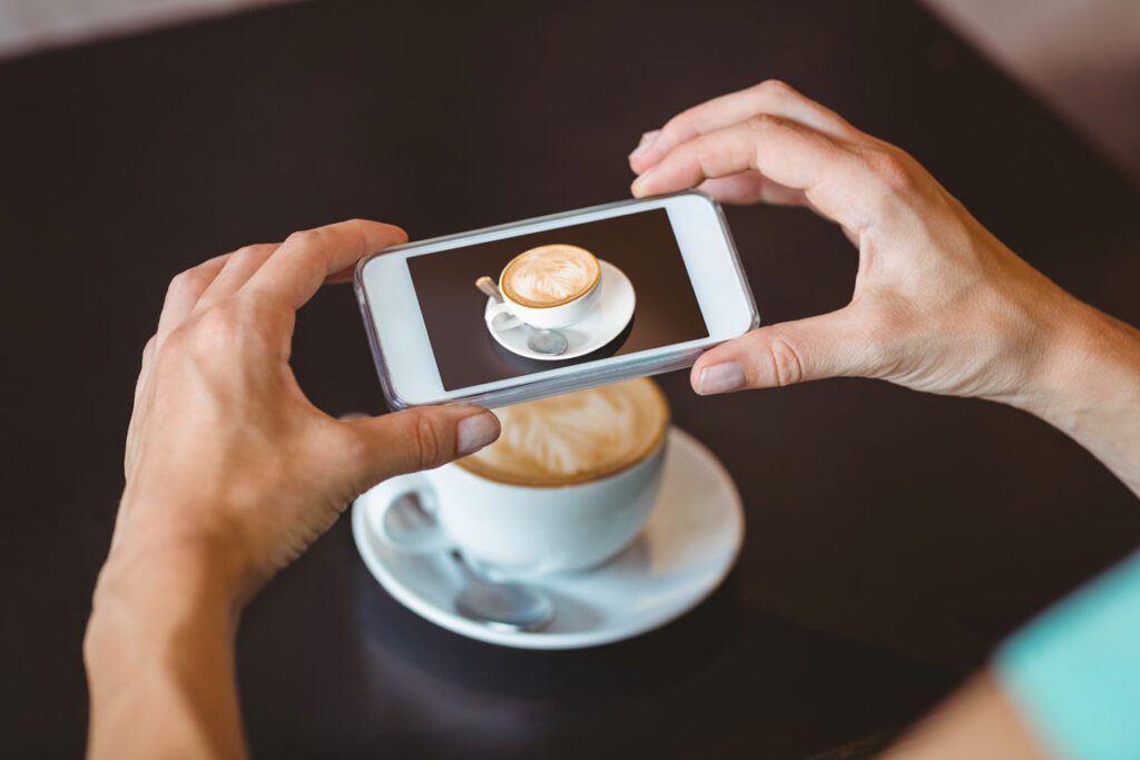 woman taking photo of her coffee on her iPhone