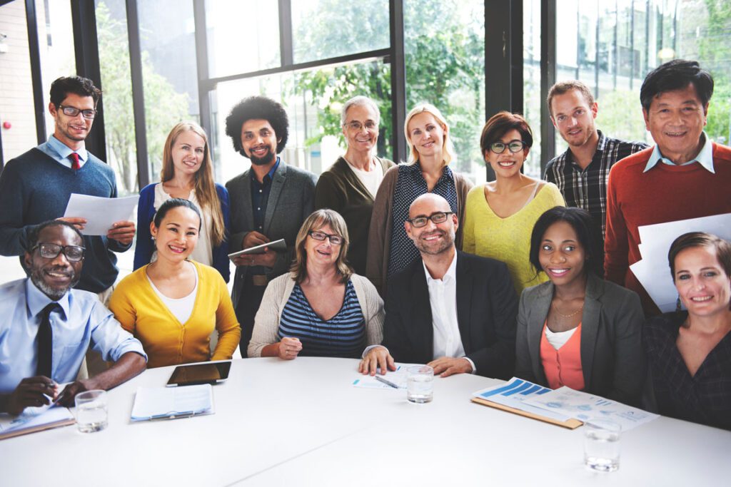 diverse group of people posing around office table