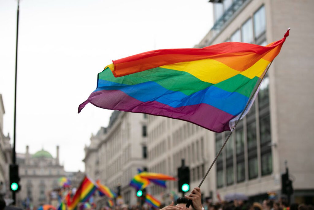 Pride flag being held up during a parade
