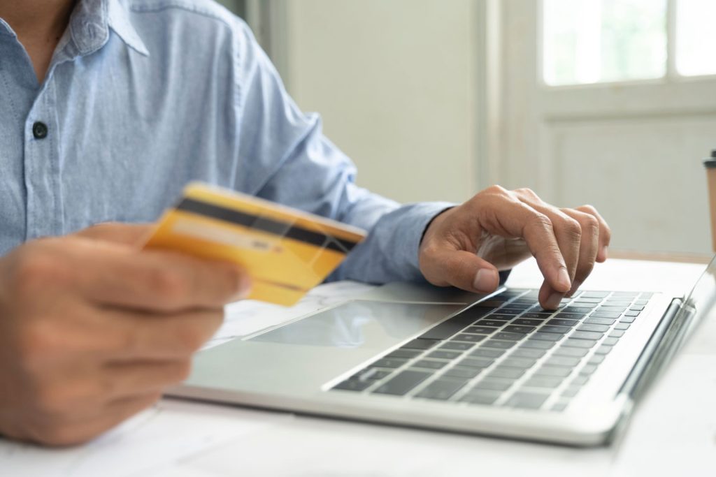 man using credit card on eCommerce website on his laptop